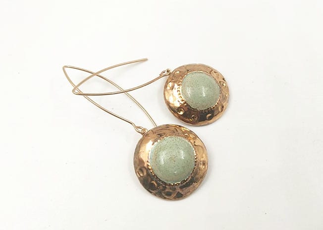 עגילים יחודיים עבודת יד מסותתים מחימר עם שכבת גלזורה ועיטורי זהב 24 קארט על גבי מתלה העשוי גולדפילד.